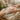 Close-up of a spa professional's hands placing a compostable paraffin wax liner over a client's hand during a luxurious treatment