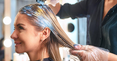 Woman getting a balayage hair color treatment at a salon