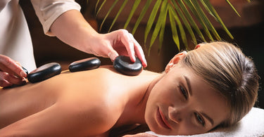 Woman receiving a hot stone massage treatment at a spa