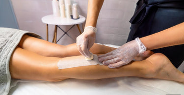 Woman getting her legs waxed in a spa with quality wax strips for effective hair removal